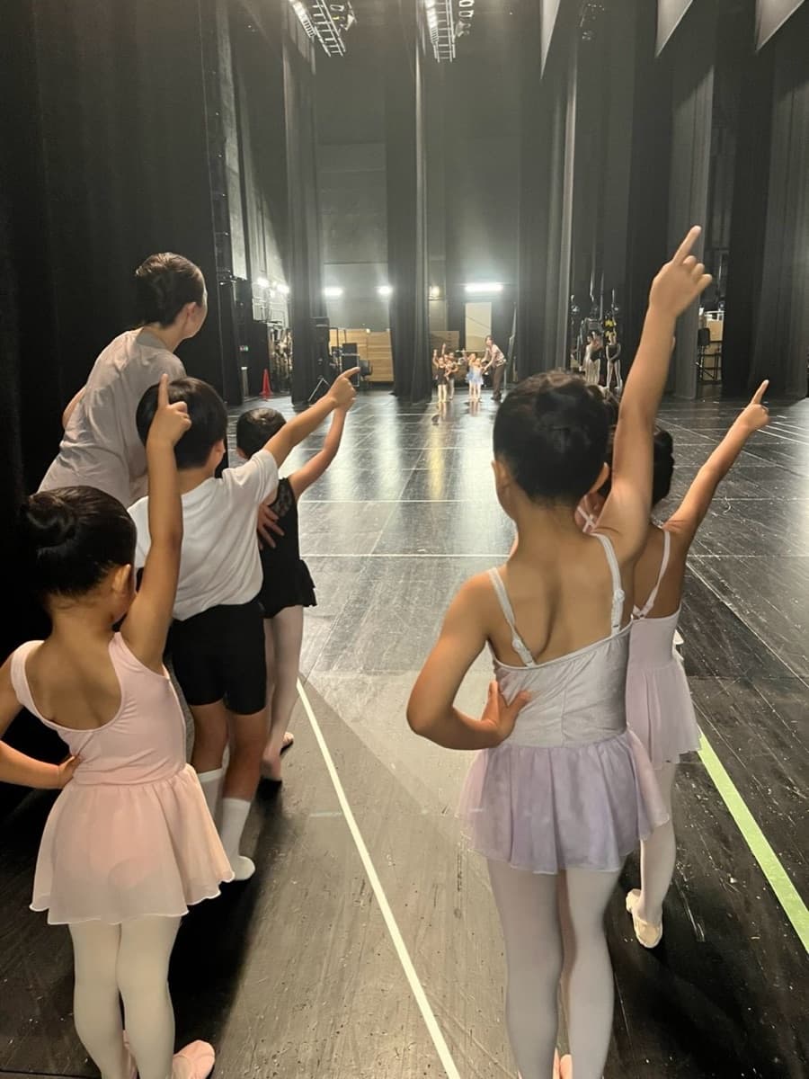 舞台袖から出番を確認する子どもたち